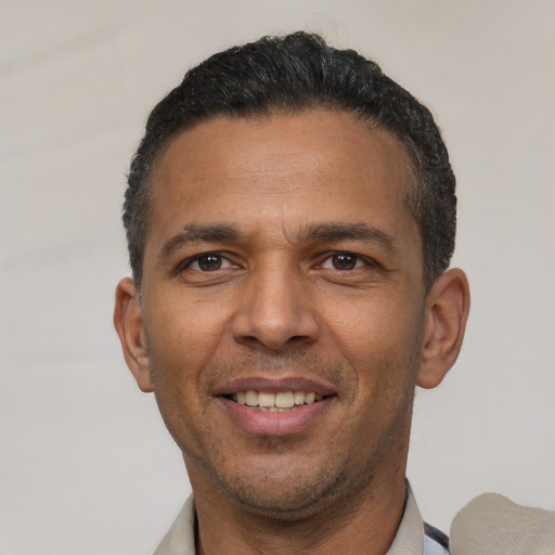 Joyful latino adult male with short  black hair and brown eyes