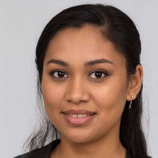 Joyful latino young-adult female with long  brown hair and brown eyes