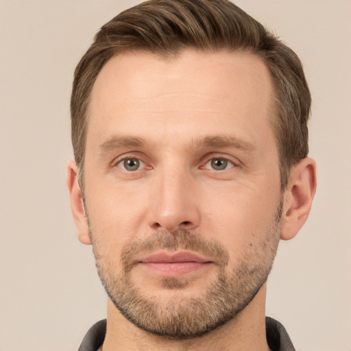 Joyful white young-adult male with short  brown hair and grey eyes