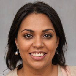 Joyful latino young-adult female with medium  brown hair and brown eyes