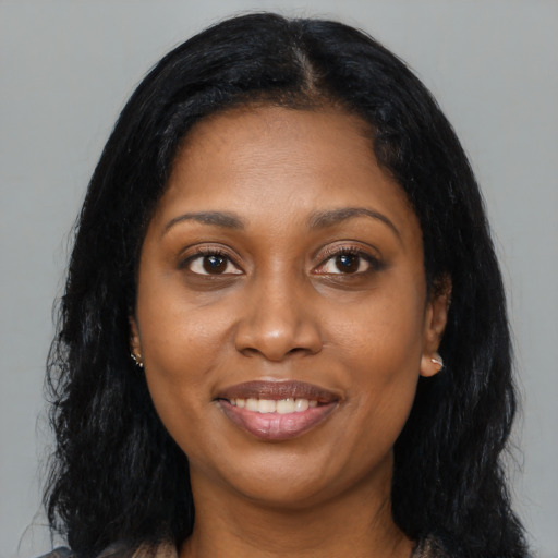 Joyful black young-adult female with long  black hair and brown eyes