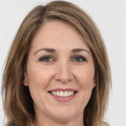 Joyful white adult female with long  brown hair and green eyes