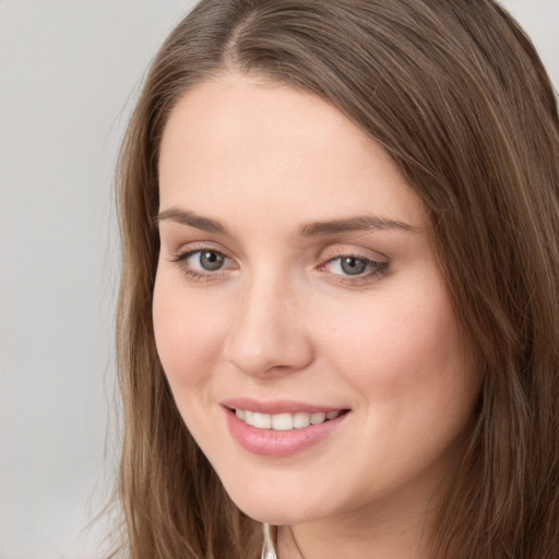 Joyful white young-adult female with long  brown hair and grey eyes