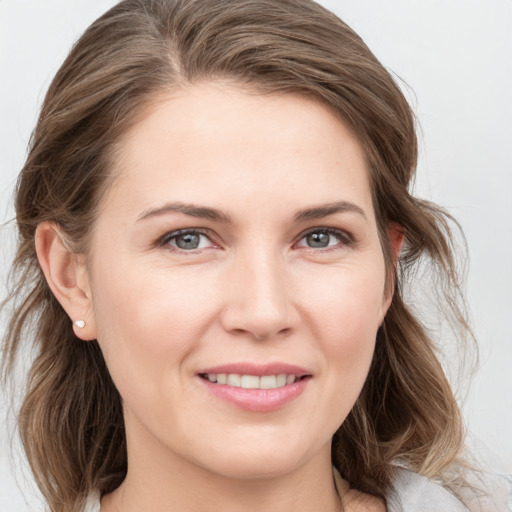 Joyful white young-adult female with medium  brown hair and grey eyes