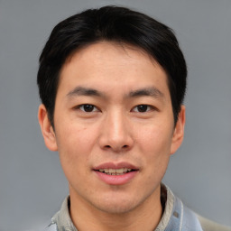 Joyful asian young-adult male with short  brown hair and brown eyes