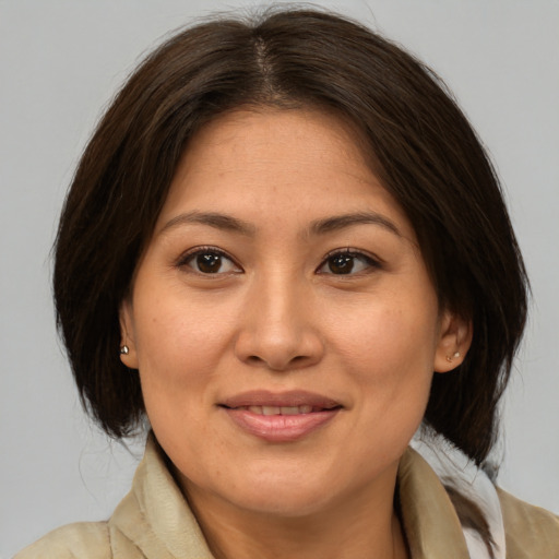 Joyful latino adult female with medium  brown hair and brown eyes