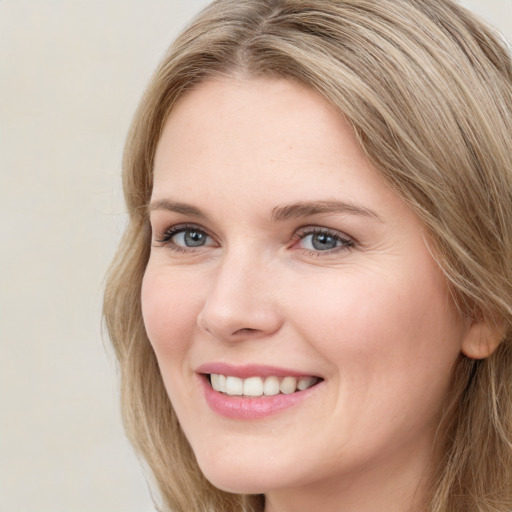 Joyful white young-adult female with long  brown hair and green eyes