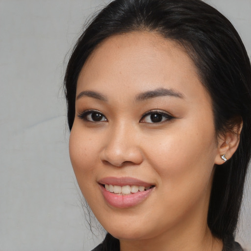 Joyful asian young-adult female with long  brown hair and brown eyes