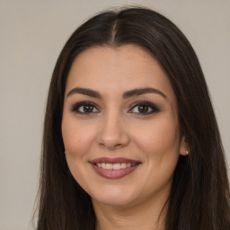 Joyful white young-adult female with long  brown hair and brown eyes