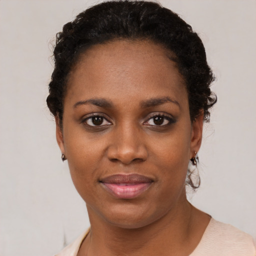 Joyful black young-adult female with short  black hair and brown eyes