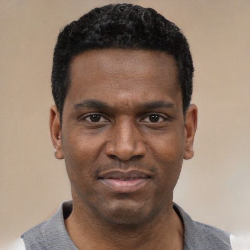 Joyful black young-adult male with short  black hair and brown eyes