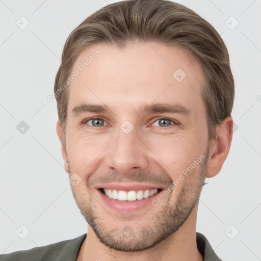 Joyful white young-adult male with short  brown hair and grey eyes