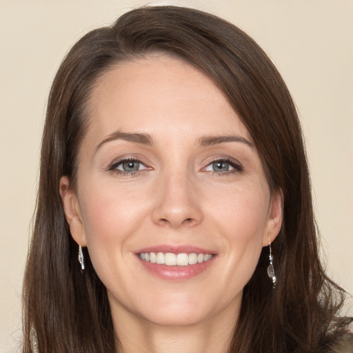 Joyful white young-adult female with long  brown hair and grey eyes