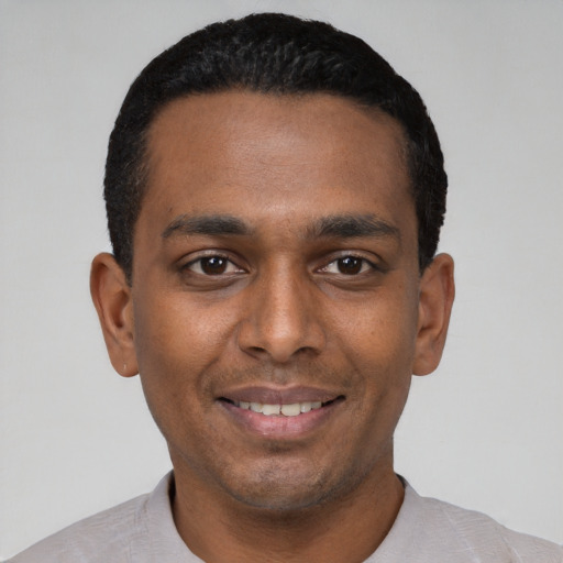 Joyful black young-adult male with short  black hair and brown eyes