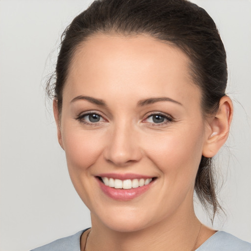 Joyful white young-adult female with medium  brown hair and grey eyes