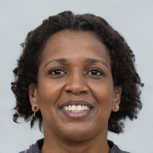 Joyful black adult female with medium  brown hair and brown eyes