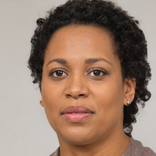 Joyful black adult female with short  brown hair and brown eyes