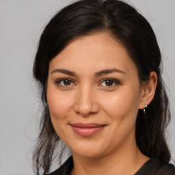 Joyful latino young-adult female with medium  brown hair and brown eyes