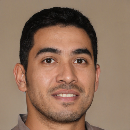 Joyful latino young-adult male with short  brown hair and brown eyes