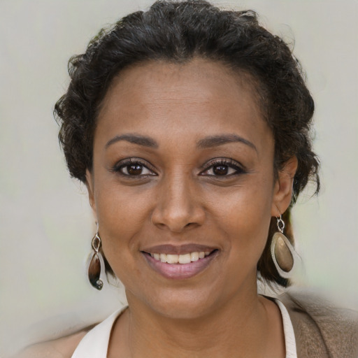 Joyful black young-adult female with short  brown hair and brown eyes