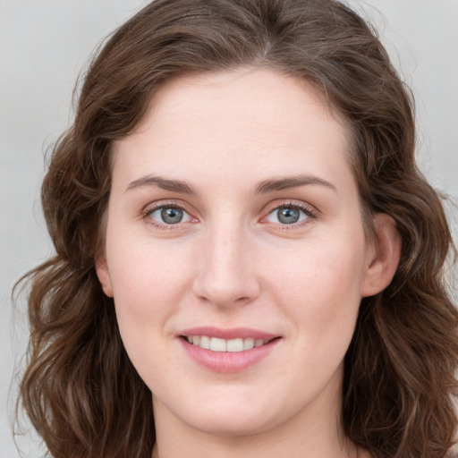 Joyful white young-adult female with long  brown hair and blue eyes