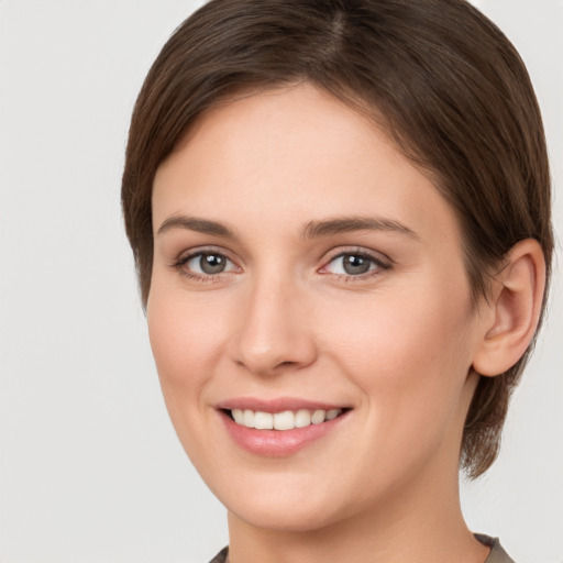 Joyful white young-adult female with medium  brown hair and grey eyes