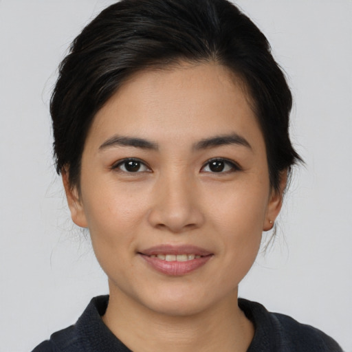 Joyful asian young-adult female with medium  black hair and brown eyes