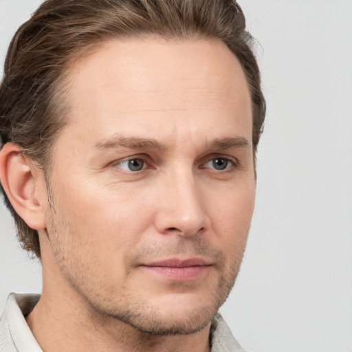 Joyful white adult male with short  brown hair and grey eyes