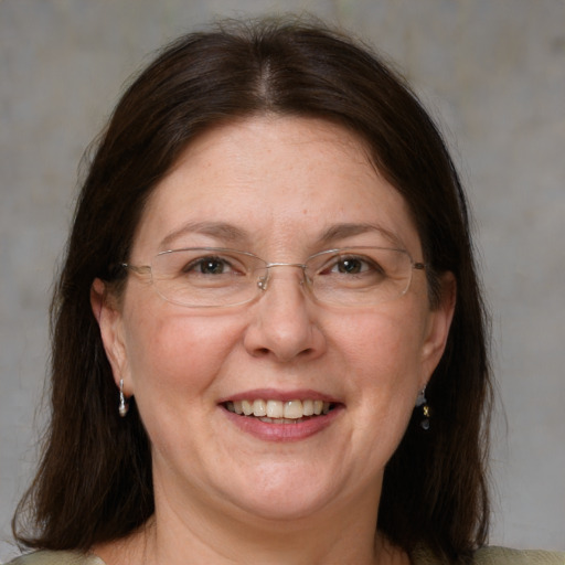 Joyful white adult female with medium  brown hair and blue eyes