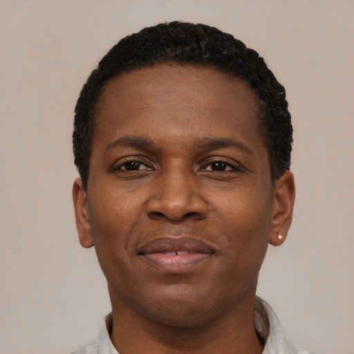 Joyful black young-adult male with short  brown hair and brown eyes