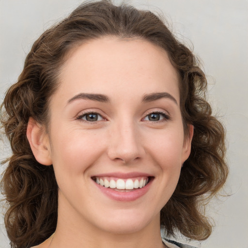 Joyful white young-adult female with medium  brown hair and green eyes