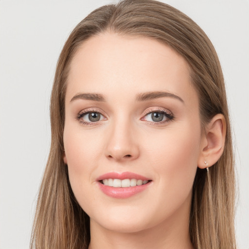 Joyful white young-adult female with long  brown hair and grey eyes