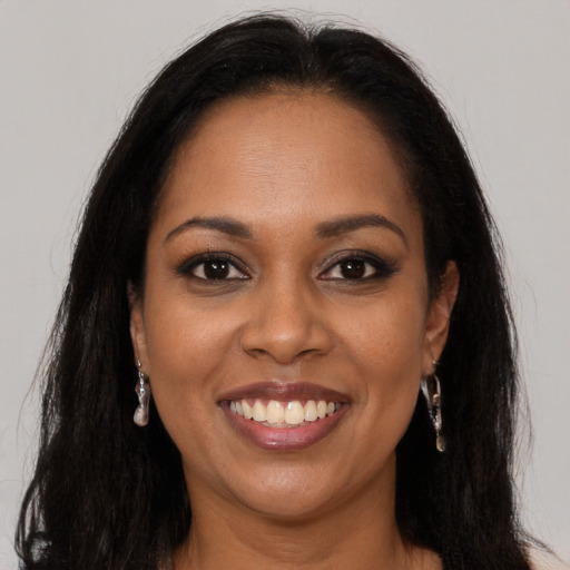 Joyful black young-adult female with long  brown hair and brown eyes
