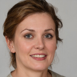 Joyful white young-adult female with medium  brown hair and blue eyes