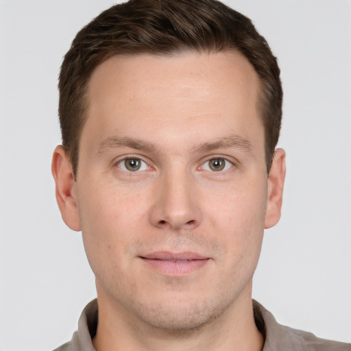 Joyful white young-adult male with short  brown hair and grey eyes