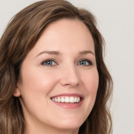 Joyful white young-adult female with long  brown hair and green eyes