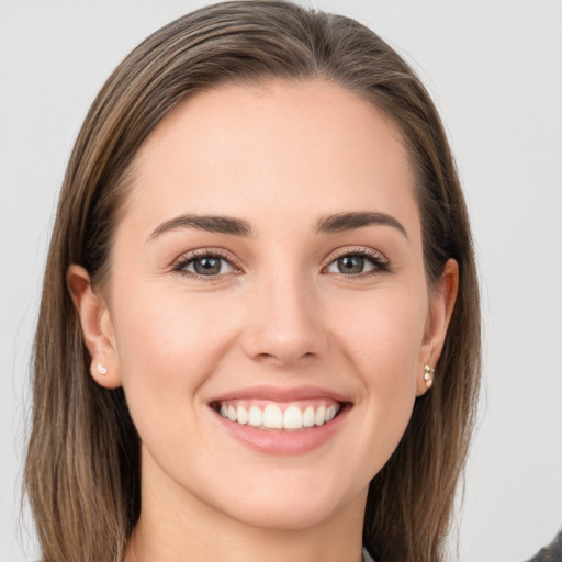 Joyful white young-adult female with long  brown hair and grey eyes