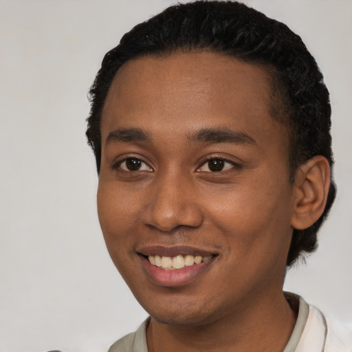 Joyful black young-adult male with short  brown hair and brown eyes