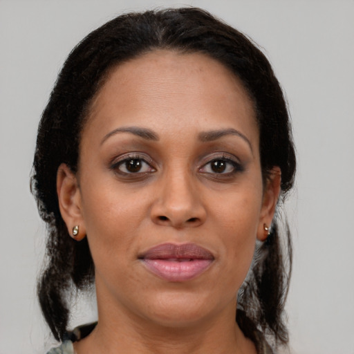 Joyful black adult female with medium  brown hair and brown eyes