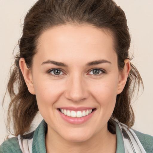 Joyful white young-adult female with medium  brown hair and grey eyes