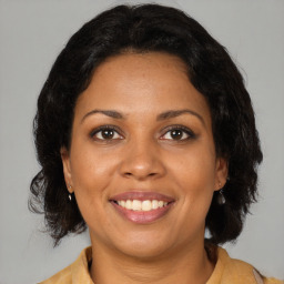 Joyful black adult female with medium  brown hair and brown eyes