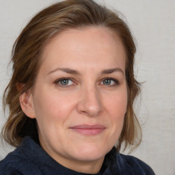 Joyful white adult female with medium  brown hair and blue eyes