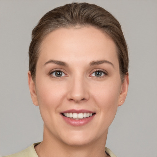 Joyful white young-adult female with short  brown hair and grey eyes