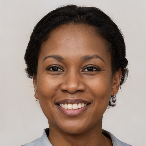 Joyful black adult female with short  brown hair and brown eyes