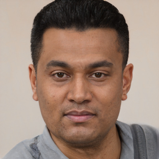 Joyful latino young-adult male with short  black hair and brown eyes