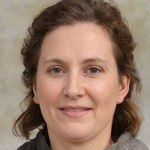 Joyful white adult female with medium  brown hair and grey eyes