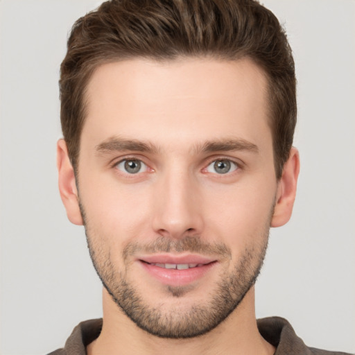 Joyful white young-adult male with short  brown hair and grey eyes