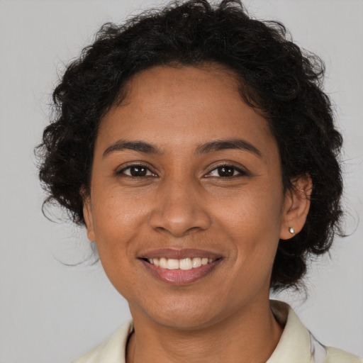 Joyful black young-adult female with medium  brown hair and brown eyes