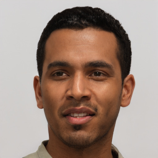 Joyful black young-adult male with short  black hair and brown eyes