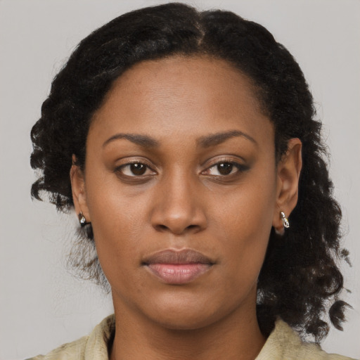 Joyful black young-adult female with medium  brown hair and brown eyes